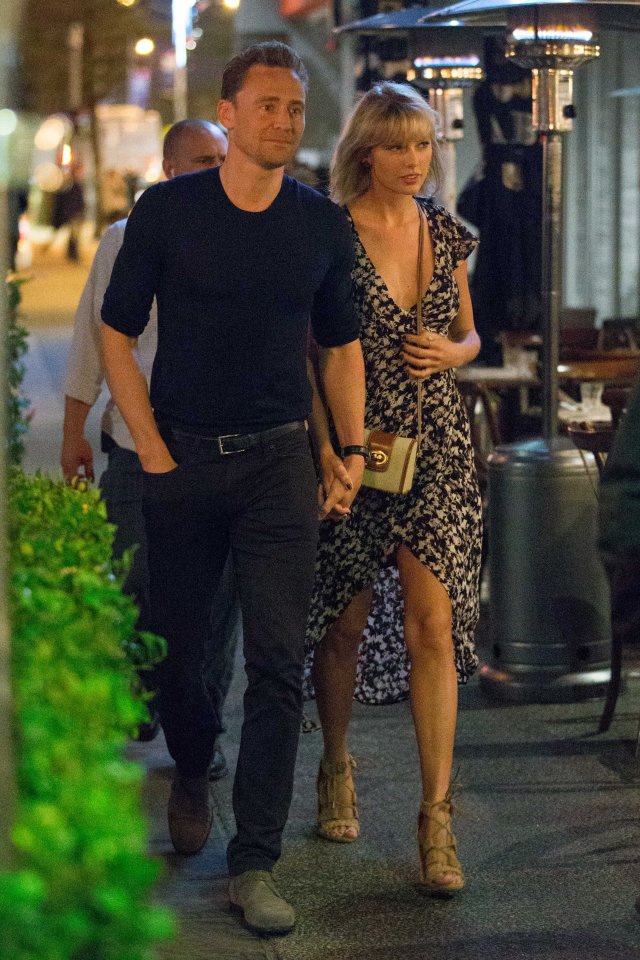  Taylor held onto Tom's hand as they strolled on the street