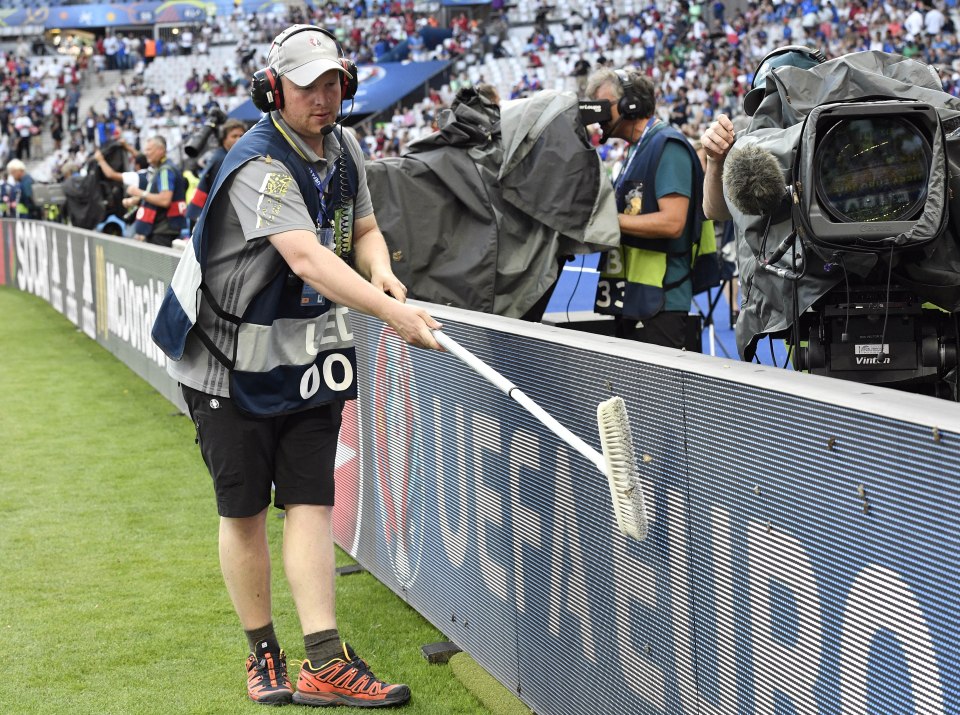  A TV camerman uses a brush to clear the moths away