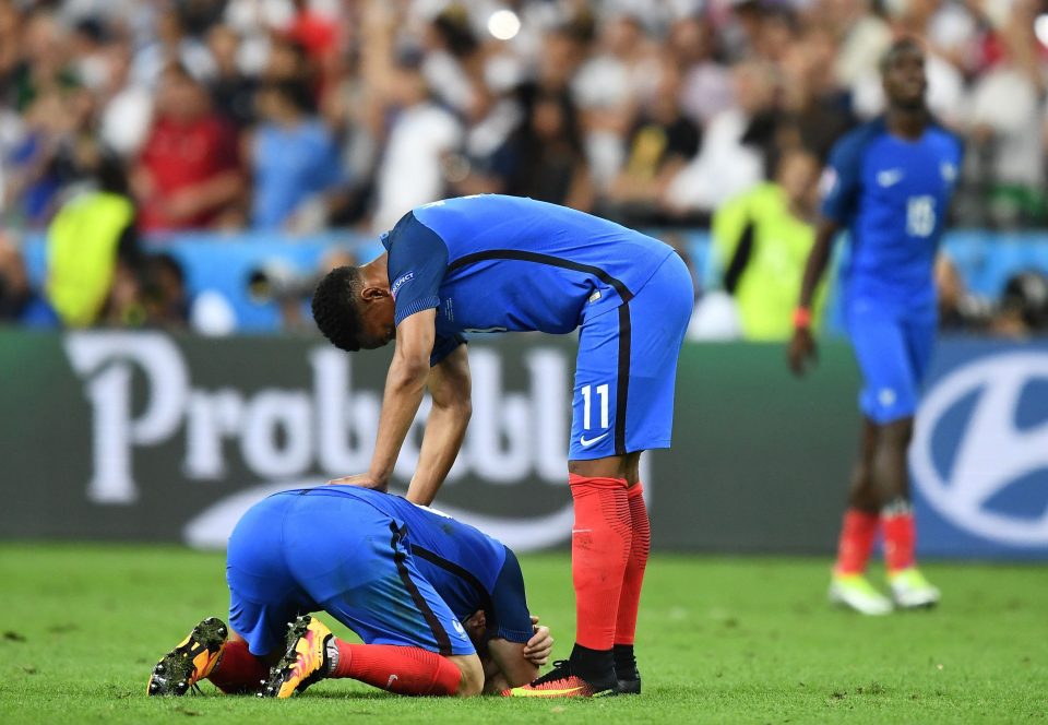  Martial tries to console a team-mate as the hosts reflect on a narrow loss against Portugal