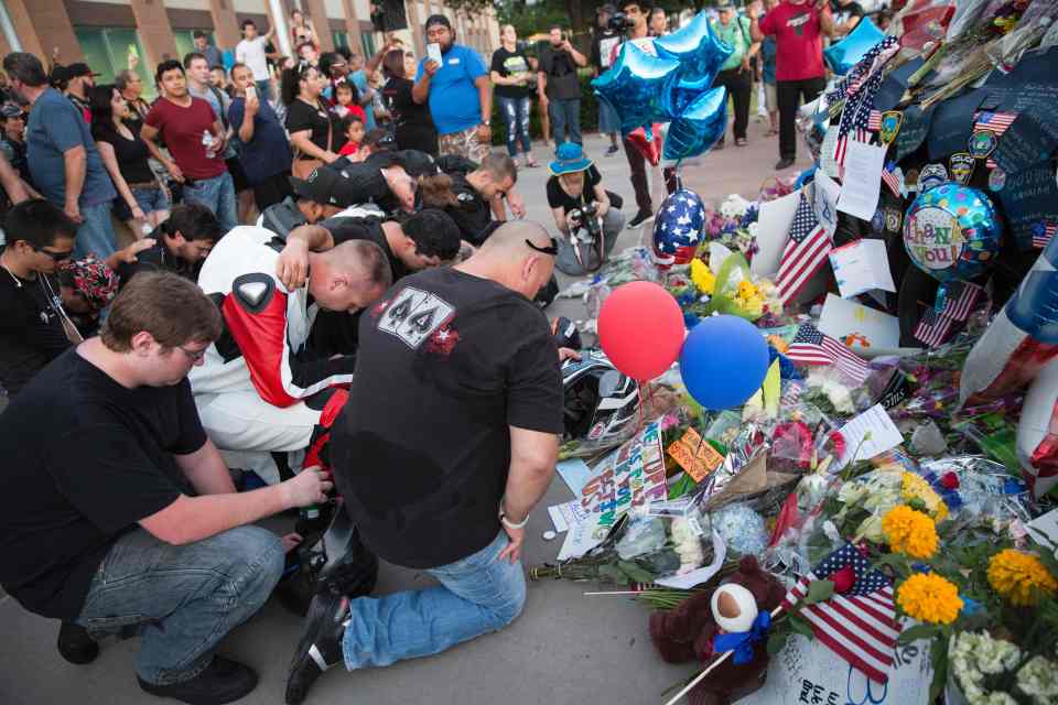 Mourners visit the Dallas Police Headquarters memorial for officers killed in the sniper attack