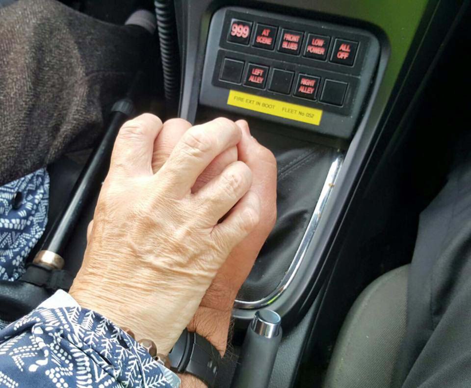 TOUCHING PHOTO SHOWS DEMETIA SUFFERER HOLD HANDS WITH POLICEMAN AS HE DRIVES HER HOME