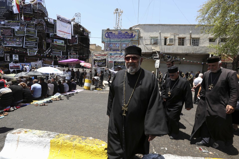  Christian clerics arrive to take part in a prayer with Sunnis and Shiites at the site