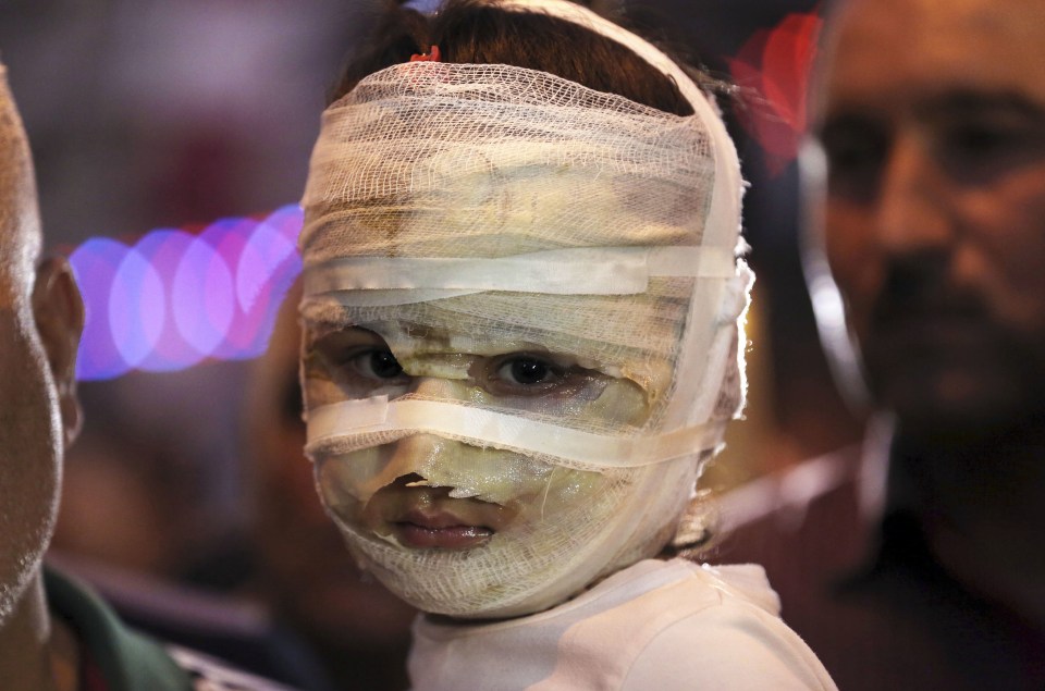  Asal Ahmed, 4, is carried by her father at the scene of a massive suicide truck bomb attack in Karada, Iraq