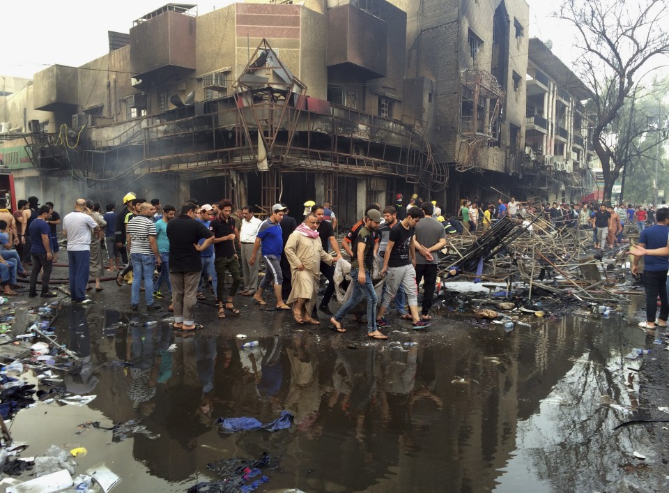  Locals carry the body of a victim killed in a massive suicide truck bomb attack in Karada, Iraq on July 3