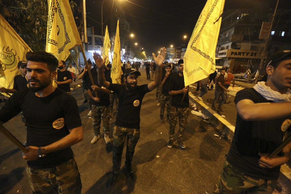  Members of the government-backed Popular Mobilisation force march at protest at the scene of the deadly attack