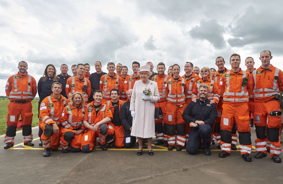 Queen Elizabeth poses with crew members including her grandson, the Duke of Cambridge, on a historic day for the UK