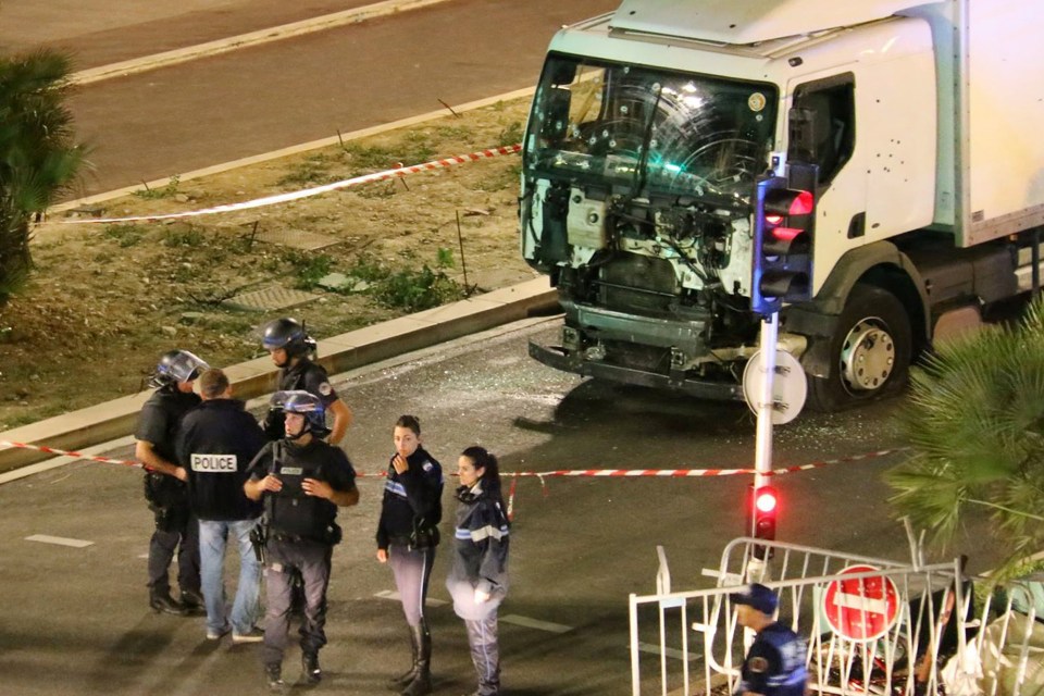  The battered truck used in the attack is surrounded by investigators