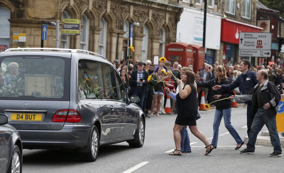 Mourners throw flowers on to the hearse carrying murdered Member of Parliament Jo Cox's as her funeral cortege 