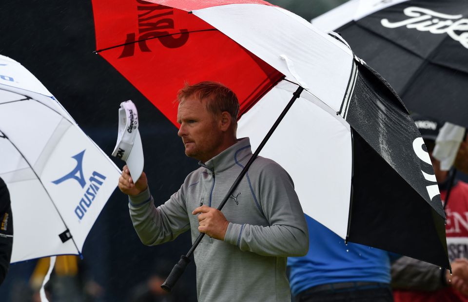 Denmarks Soren Kjeldsen shelters under an umbrella on the 18th green during his second round on day two of the 2016 British Open Golf Championship at Royal Troon in Scotland on July 15, 2016. The second round got underway on Friday morning, with expectations for far more trying conditions at Royal Troon. / AFP PHOTO / ANDY BUCHANAN / RESTRICTED TO EDITORIAL USEANDY BUCHANAN/AFP/Getty Images