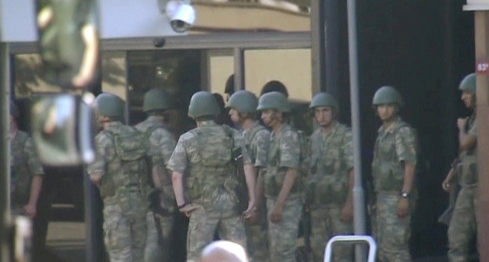 Armed soldiers waiting at the entrance of TRT state television as they prepare to surrender to the police after a failed coup attempt