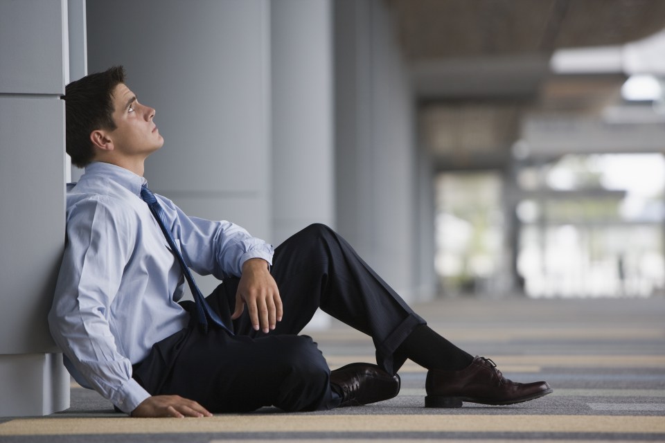 Overwhelmed man sitting on floor