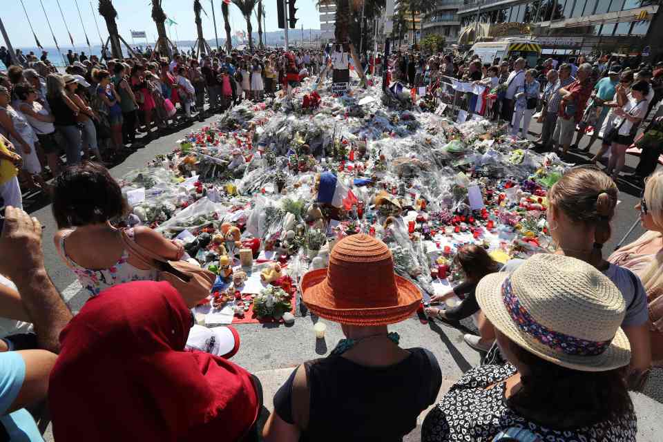  Tributes . . . crowd gathers around tributes to the victims