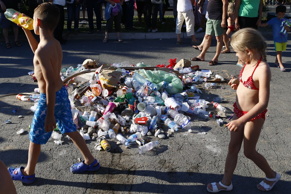  Children walk around the rubbish where the killer was shot after claiming 84 lives