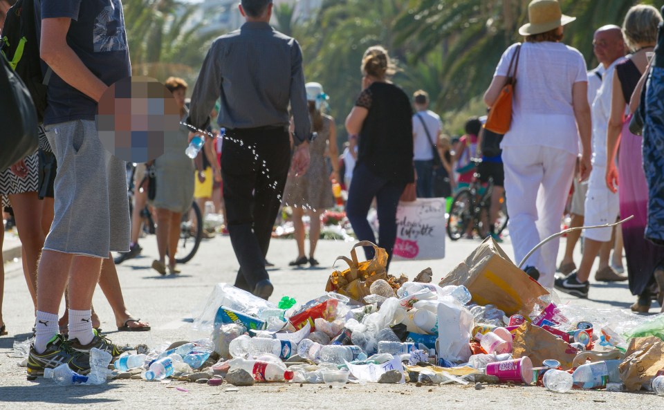  A man relieves himself on the pile of rubbish gathered to shame the Bastille Bastard