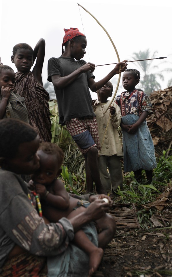 Mbuti Pygmy children play with a bow and arrow