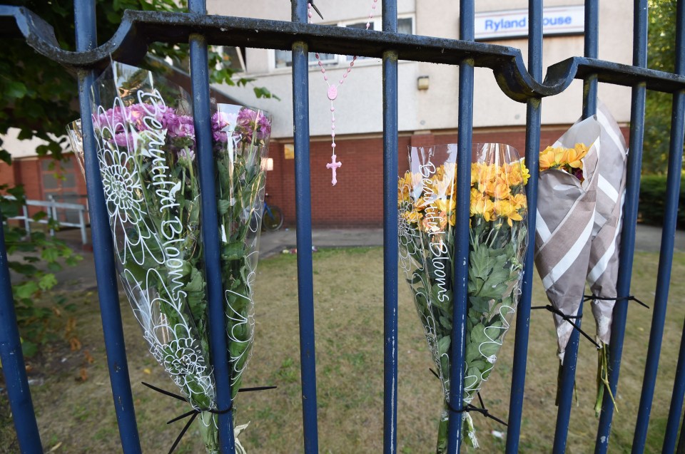 Devastated neighbours have attached flowers to the gates outside the tower block where the tot fell to her death 