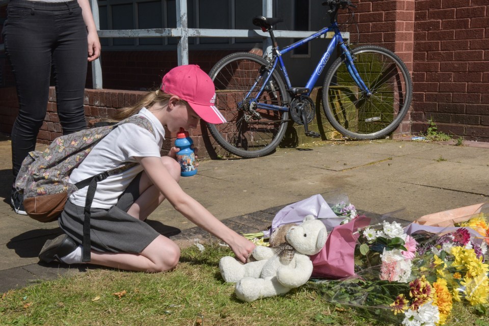 A young girl lays a teddy bear at the scene of the tragedy 