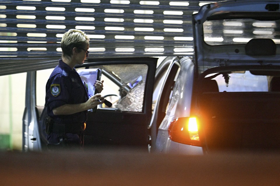  Police officers inspect the mangled car after fears it contains gas cylinders