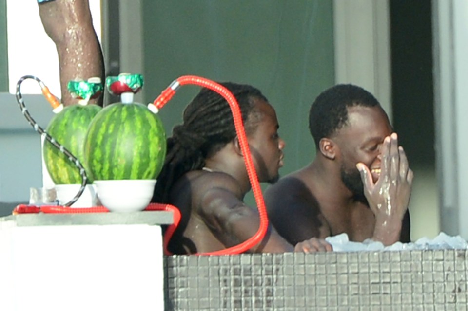 Romelu Lukaku and a friend chill by the pool next to water melon shisha pipes