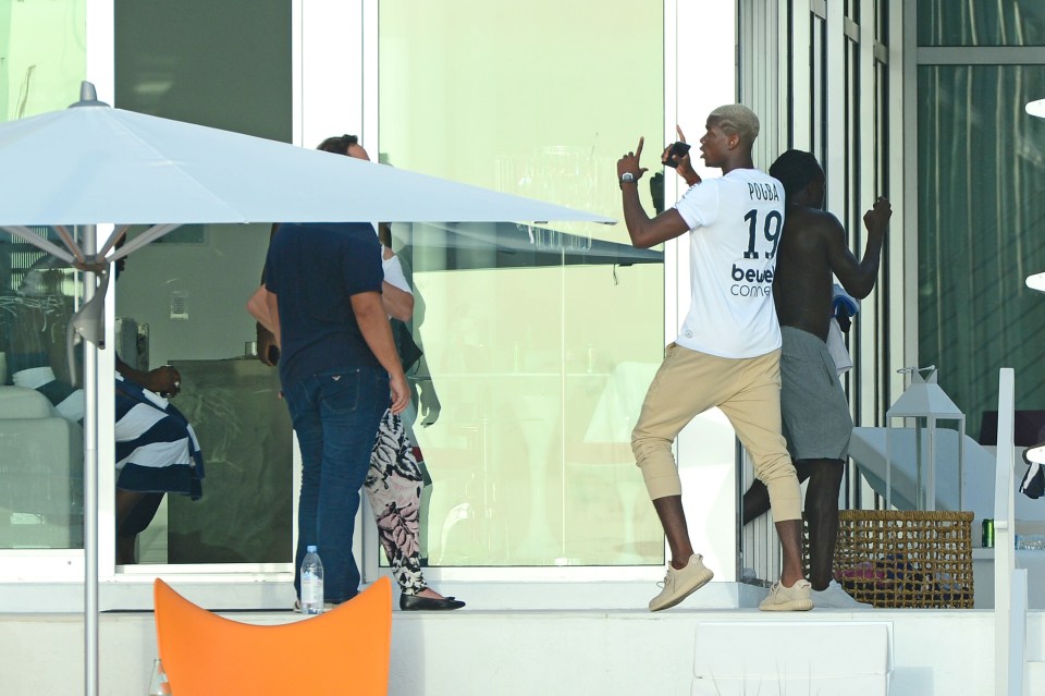 Pogba, wearing a T-shirt with his own name and number on the back, tries to explain his action to agent Raiola