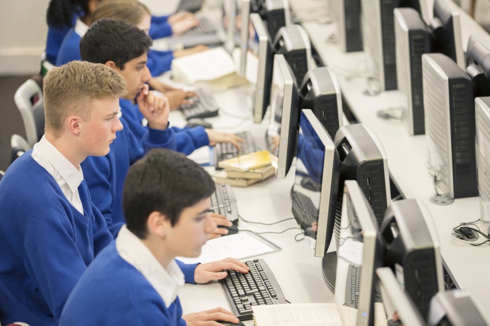 Teenage students using computers in computer room