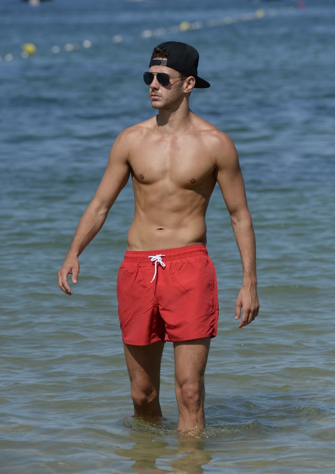 Scott, 27, showed off his enviable six pack while wearing a pair of red swim shorts 