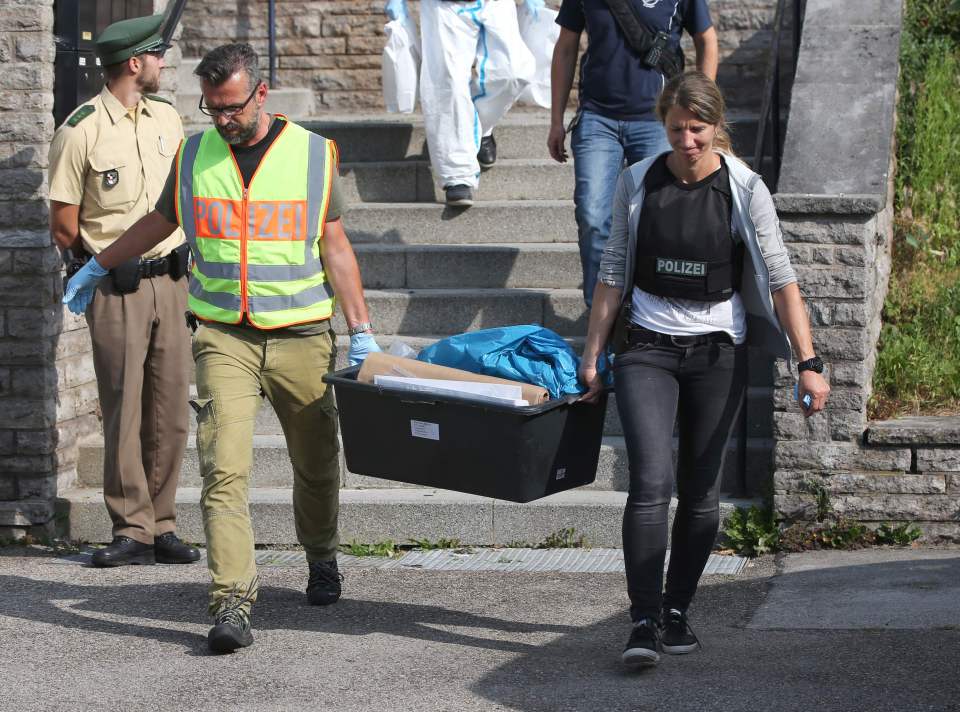 Police officers leave after conducting a search at a refugee shelter