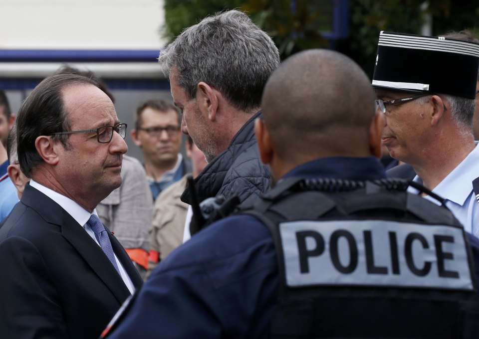 French President Francois Hollande speaks with police forces after two assailants had taken five people hostage in the church at Saint-Etienne-du -Rouvray