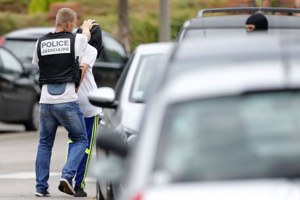 A plain-clothes police officer is seen to march the youngster away in handcuffs