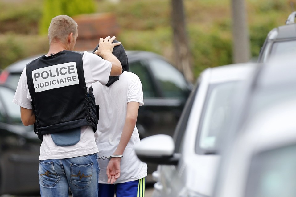 A young man is arrested by police on Thursday afternoon following the Normandy horror