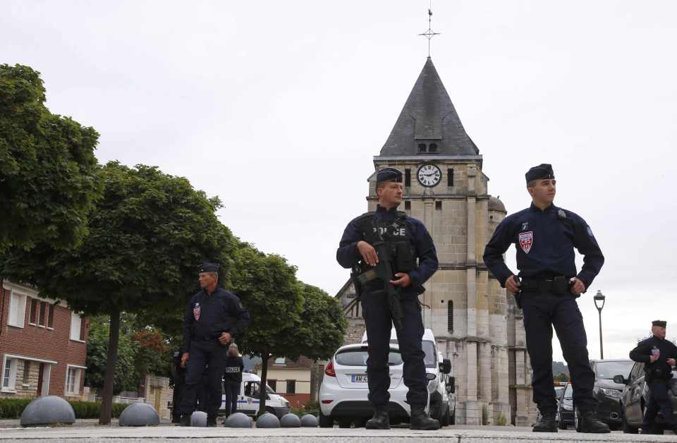 French police stand guard in front of the church where a priest was murdered by two ISIS fanatics