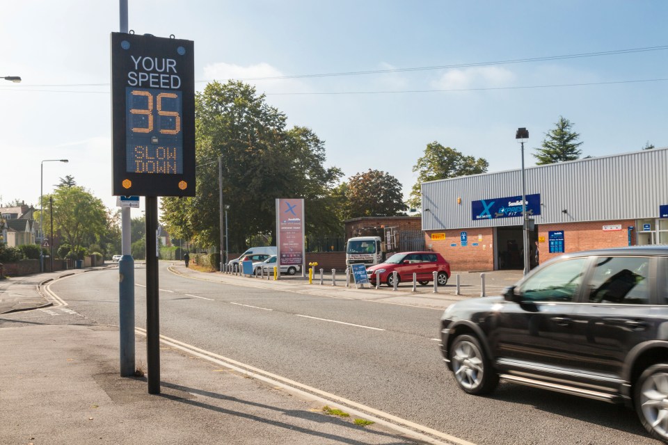 Car exceeding the speed limit as it passes a traffic speed warning indicator in Nottinghamshire, England, UK