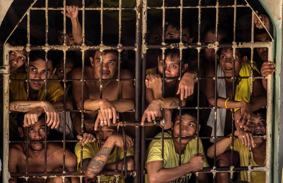  Inmates peek from their cell inside the Quezon City Jail in Manila