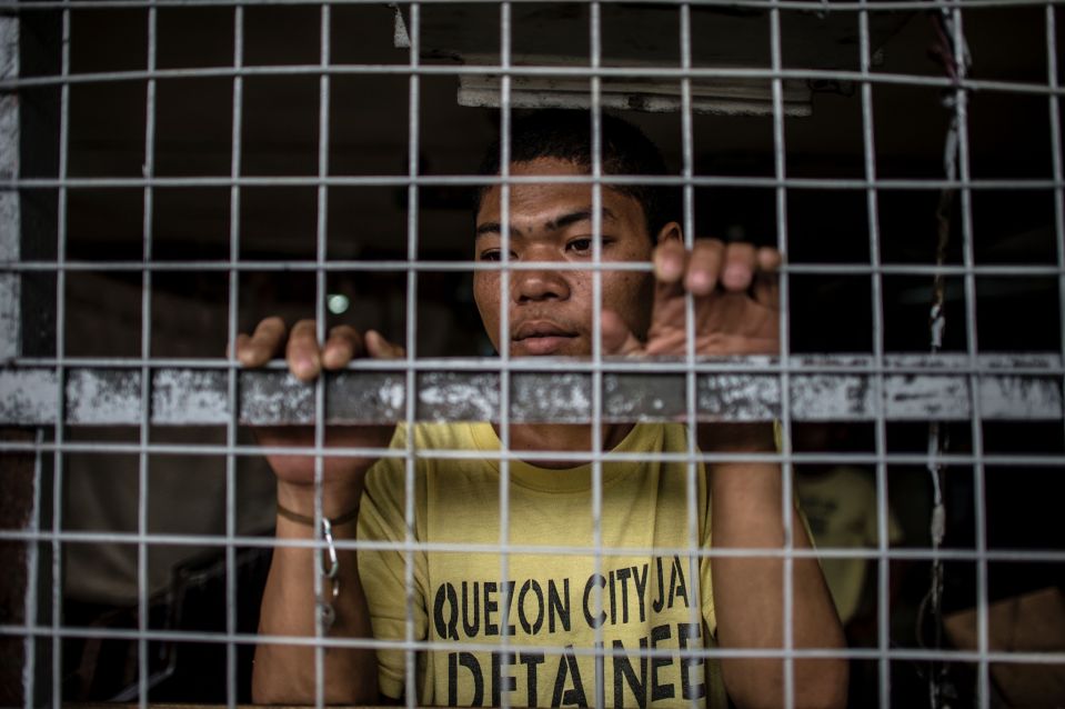  An inmate looks on other detainees participating in a group dance contest