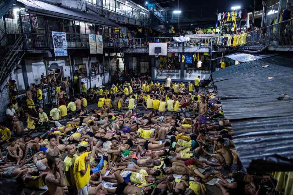  Prisoners crowd into any available space to rest inside their overcrowded cage