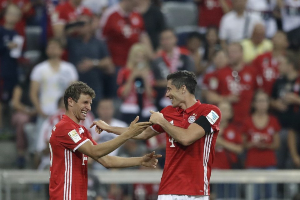 Bayern's Robert Lewandowski, right, celebrates with teammate Thomas Mueller after scoring his side's third goal during the German Bundesliga soccer match between FC Bayern Munich and SV Werder Bremen at the Allianz Arena stadium in Munich, Germany, Friday, Aug. 26, 2016. (AP Photo/Matthias Schrader)