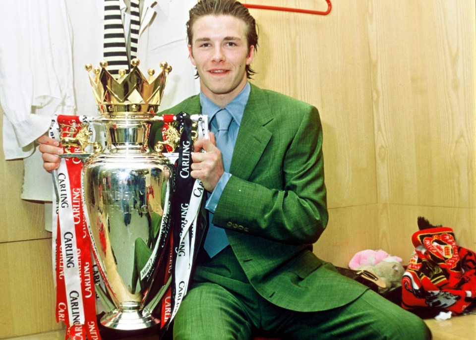 MANCHESTER, ENGLAND - MAY 11: David Beckham of Manchester United celebrates in the dressing room with the FA Carling Premiership trophy after the match between West Ham United v Manchester United at Upton Park on May 11, 1997 in London. Manchester United 2 West Ham United 0. (Photo by John Peters/Manchester United via Getty Images)