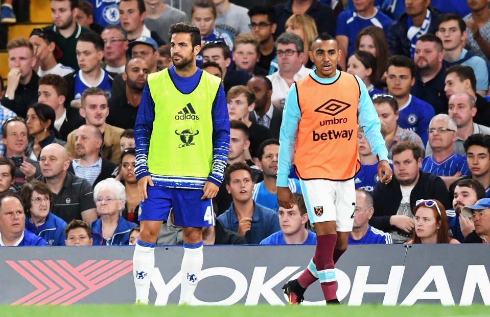 LONDON, ENGLAND - AUGUST 15: Cesc Fabregas of Chelsea looks on from the sidelines with Dimitri Payet of West Ham United during the Premier League match between Chelsea and West Ham United at Stamford Bridge on August 15, 2016 in London, England. (Photo by Michael Regan/Getty Images)