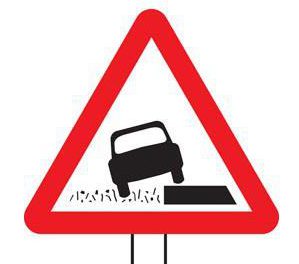 The lopsided car indicates that the roads verges are softer than the road surface up ahead. A plate under the sign will inform drivers of the distance this applies for