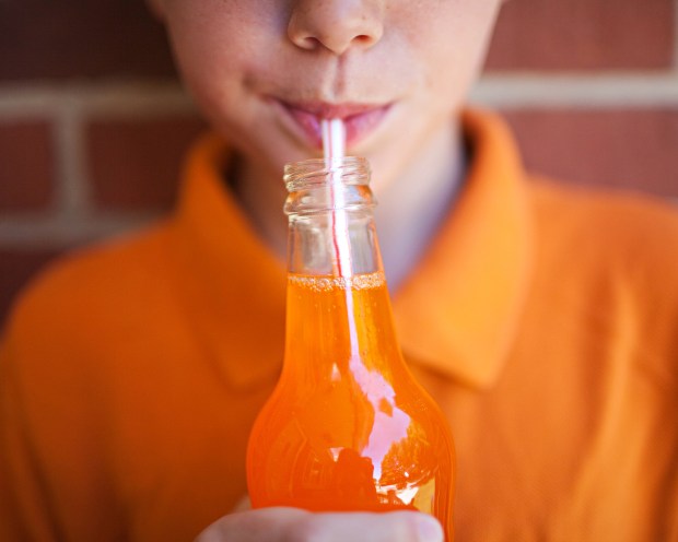 Boy drinking orange soda