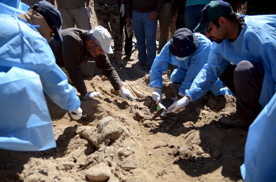  Members from the Iraqi forensic team search to extract the remains of the bodies belonging to Shi'ite soldiers from Camp Speicher who were killed by Islamic State militants