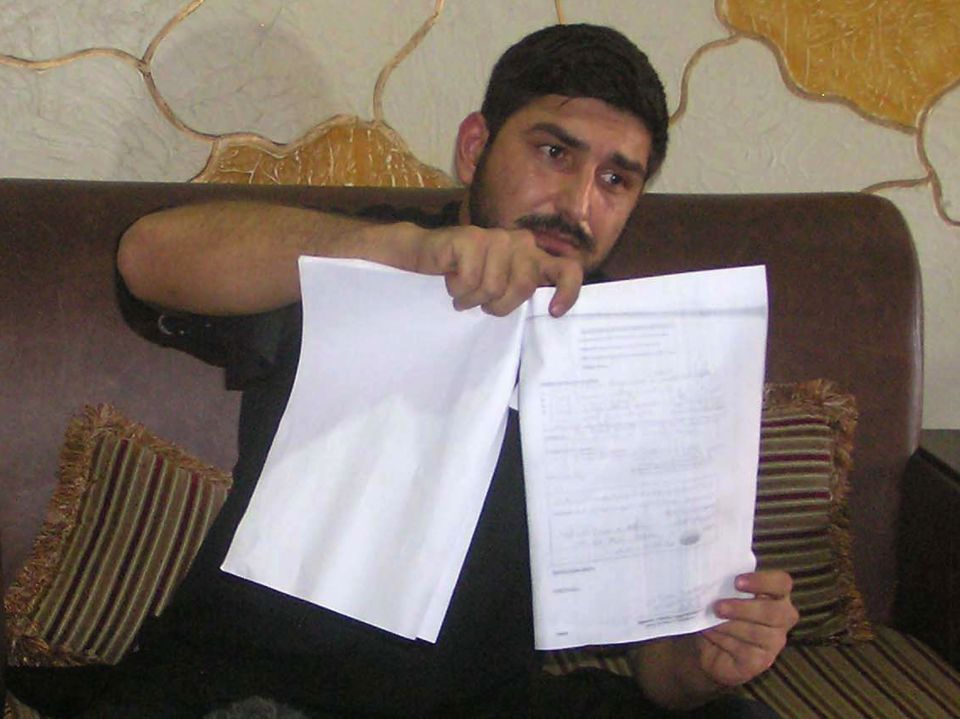 Mukhtar Kazam, the husband of late British woman Samia Shahid, as he displays her post-mortem report during a press conference 