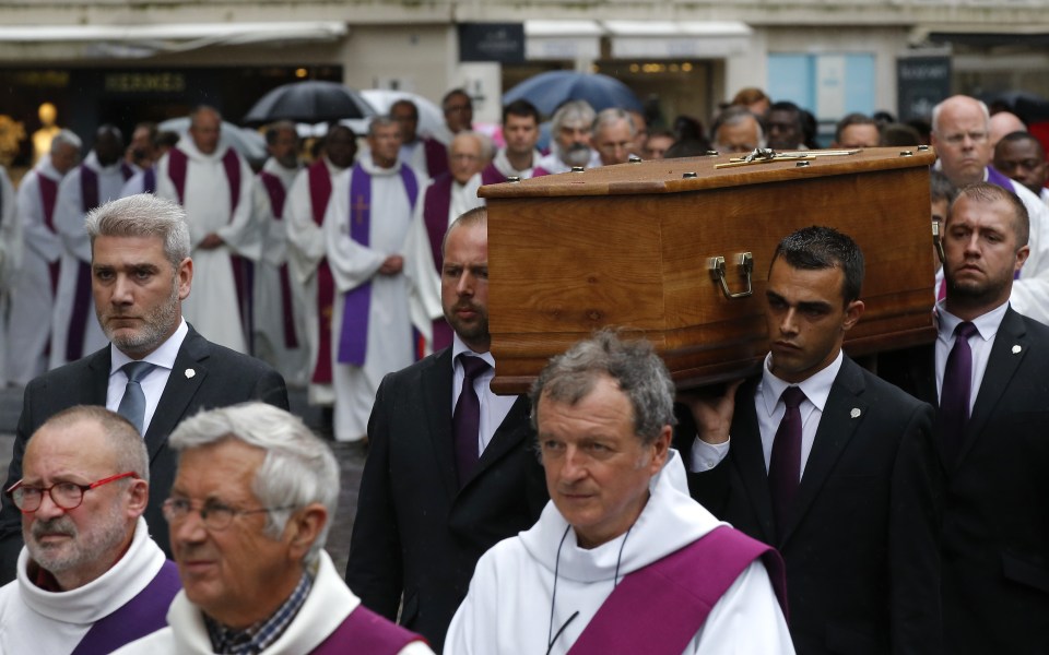 Father Hamel's coffin is carried into the cathedral for the funeral service