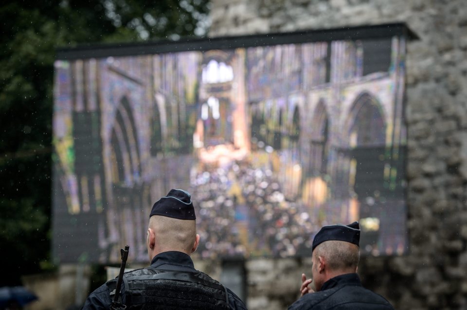 Police officers stand guard outside the cathedral where the service was held today