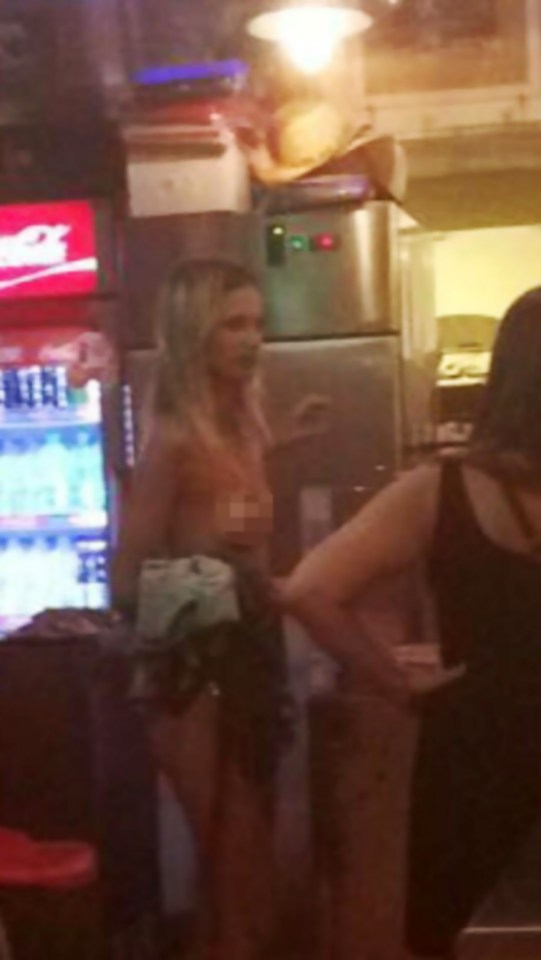  'So hungry I'd eat my top' ... Naked woman believed to be a Brit waits patiently in a fast food restaurant