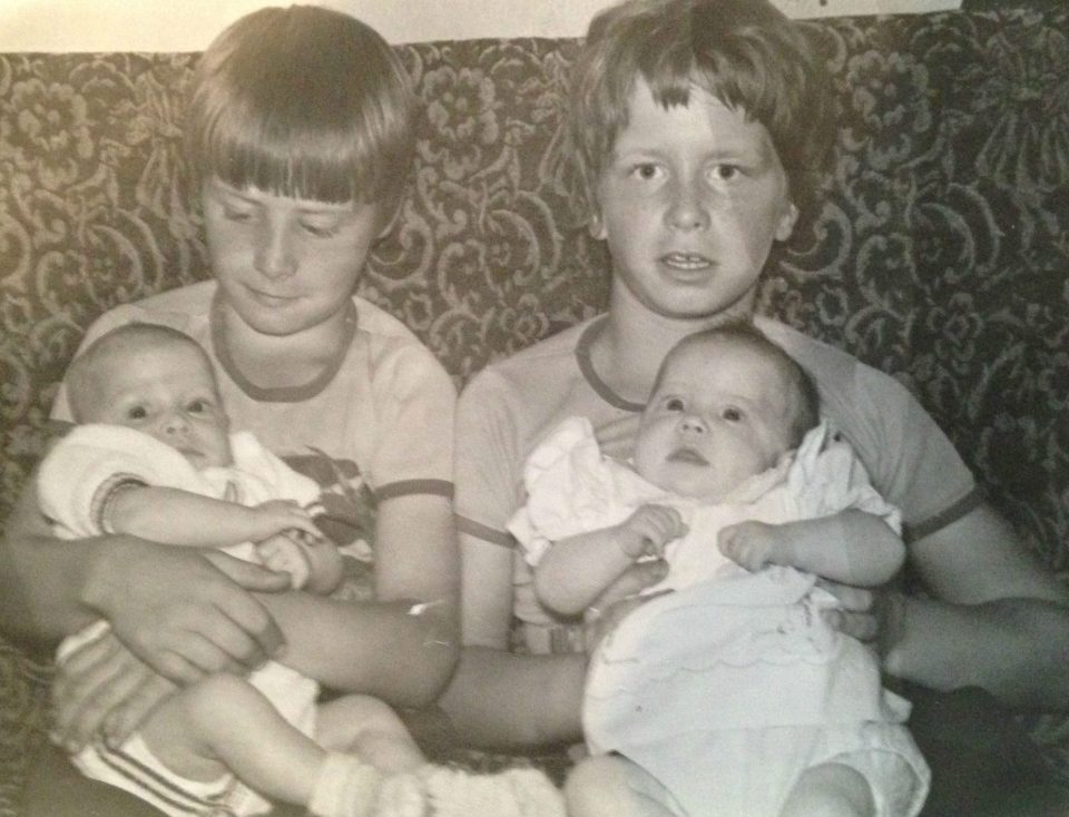 Mark and Martin as children, holding their siblings Kirsty and Karl