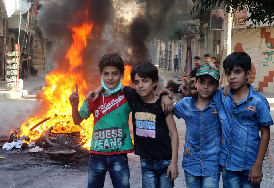  Syrian children pose for the camera in a neighbourhood in Aleppo, Syria