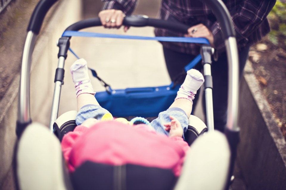 Mother pushing baby in pram