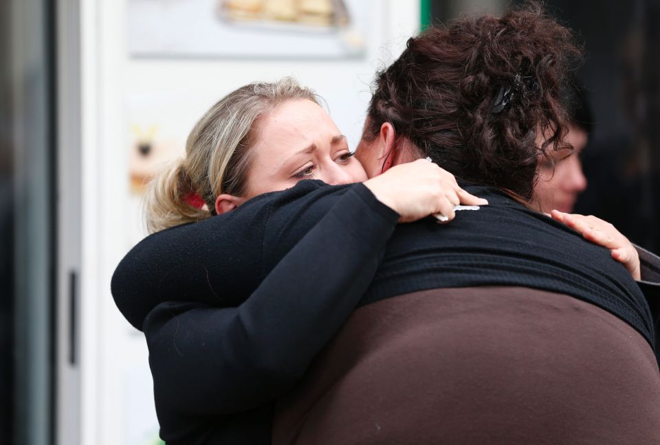  Women comfort each other outside the restaurant