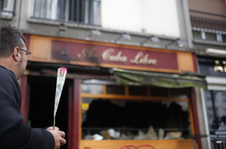  A man lays a flower at the scene of the blaze